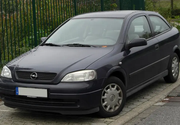 Ciemnoszary Opel Astra G 1.6 16v stoi na chodniku.