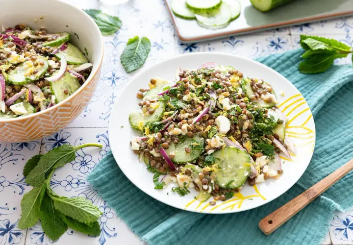 Salade de lentilles, concombre, oignon rouge et feta émiettée, garnie d'herbes fraîches. Un délice léger et savoureux.