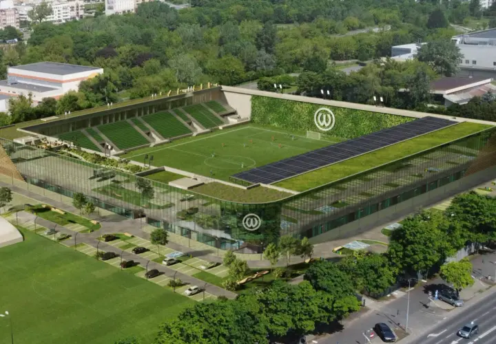 Nowoczesny stadion Warty Poznań z zielonymi dachami, panelem słonecznym i ścianą porośniętą roślinnością.