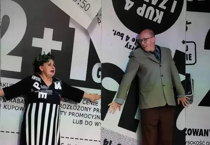 Aktorzy na scenie Teatru Kamienica w spektaklu "Metoda na wnuczka". Kobieta w czarnej sukni, mężczyzna w garniturze.
