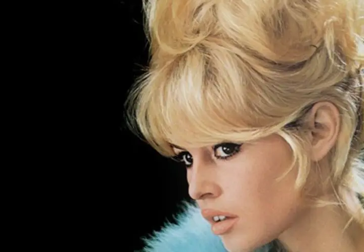 Icono de los moda peinados de los 60 con cabello rubio voluminoso y maquillaje dramático.