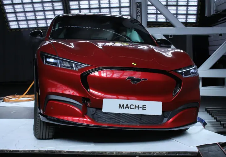 Czerwony Ford Mustang Mach-E w studiu z tabliczką "MACH-E".