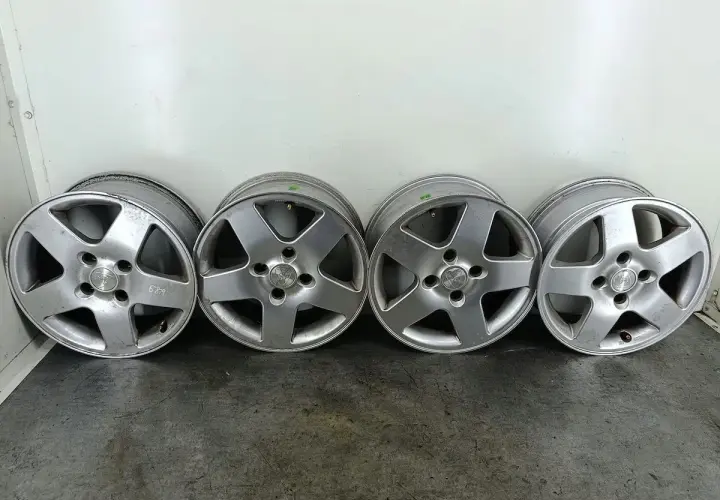 Cztery felgi aluminiowe do Peugeot 206. Widoczny rozmiar kół sugeruje standardowe wyposażenie.