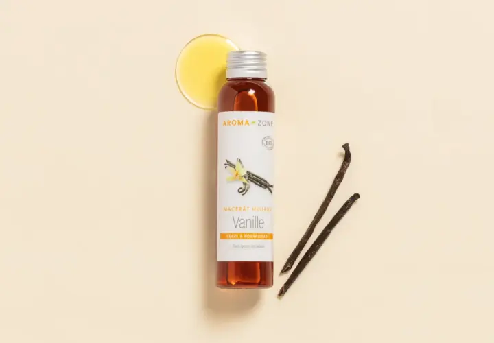 Flacon d'huile de vanille Aroma-Zone, avec des gousses de vanille et une goutte d'huile dorée.