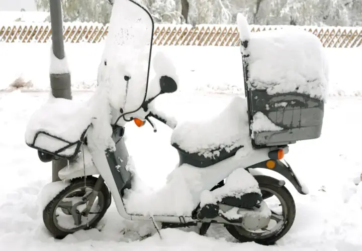 Moto cubierta de nieve, lista para no arrancar en frío.