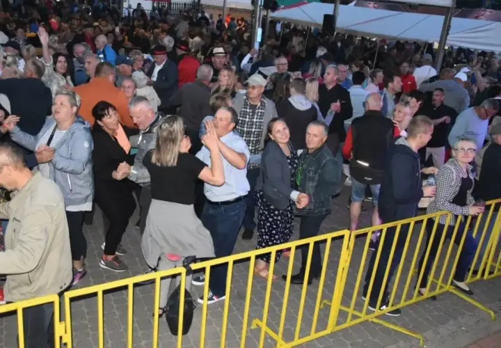 Tłum ludzi bawi się na ostrzyce koncert, tańcząc i świętując.