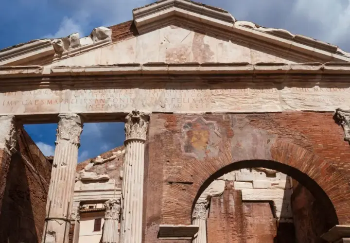 Antico portico d'Ottavia a Roma, con iscrizioni latine e resti di affreschi su mattoni antichi.