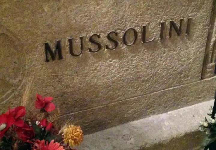 Grabstein mit der Inschrift "MUSSOLINI" und Blumen. Hier ist das Grab von Mussolini.