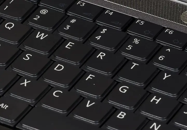 Zbliżenie na klawiaturę laptopa z widocznymi klawiszami QWERTY. Różne rodzaje klawiatur w telefonie mogą przypominać ten układ.