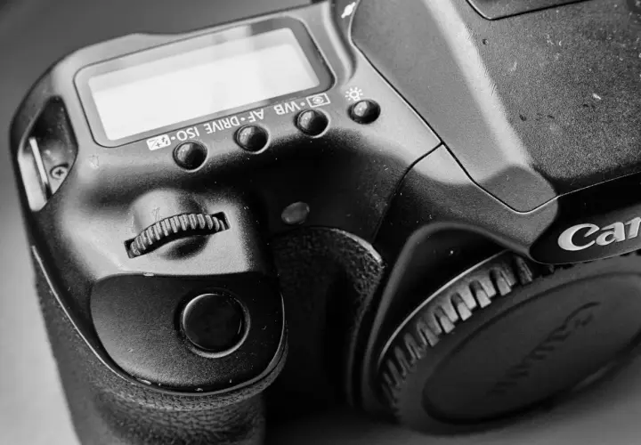 Zbliżenie na lustrzankę Canon 1000D, widoczne przyciski sterujące i pokrętło.