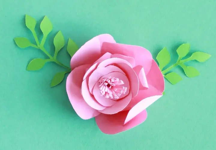 Kwiaty z papieru 3d jak zrobić? Różowa róża z zielonymi listkami, idealna do dekoracji.