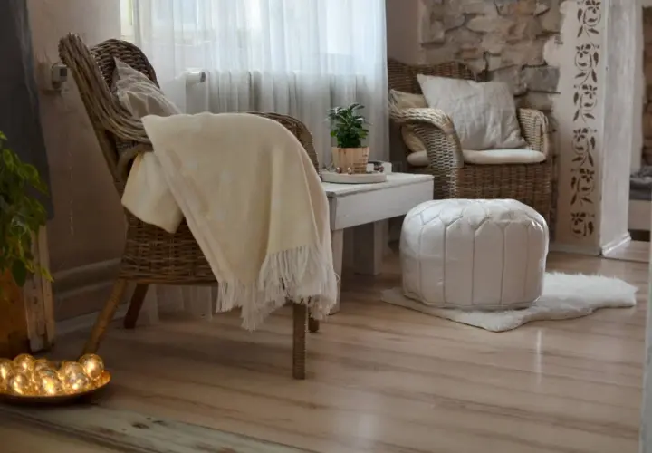 Gemütliche **hygge einrichtung**: Korbstühle, ein weicher Überwurf und ein weißer Pouf laden zum Entspannen ein.