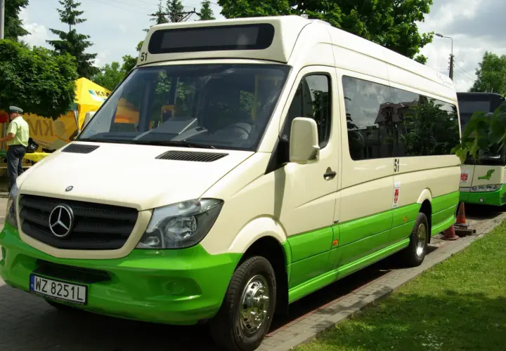 Biało-zielony bus Mercedes-Benz z numerem 51 na dachu, zaparkowany na zewnątrz.