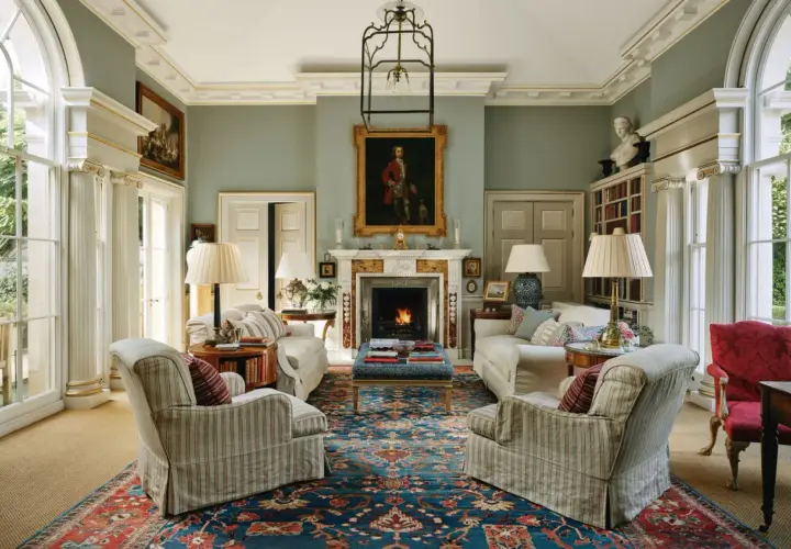 Elegant living room with fireplace, portraits, and plush seating, showcasing the expertise of home design consultants.