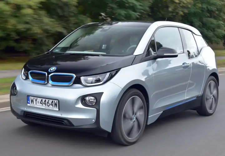 Srebrno-czarny BMW i3, elektryczny samochód, jedzie po drodze.