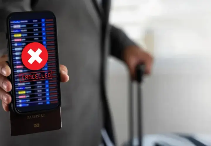 Telefon z napisem "CANCELLED" i czerwonym krzyżykiem, pod nim paszport. Podróż z Ryanair zwrot biletu stał się niemożliwy.