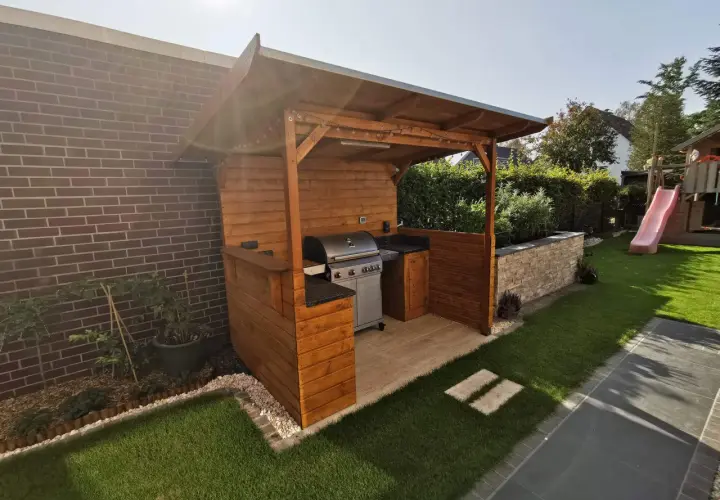 Ein schöner Grillunterstand, den man selber bauen kann, mit Grill, Arbeitsfläche und Beleuchtung.