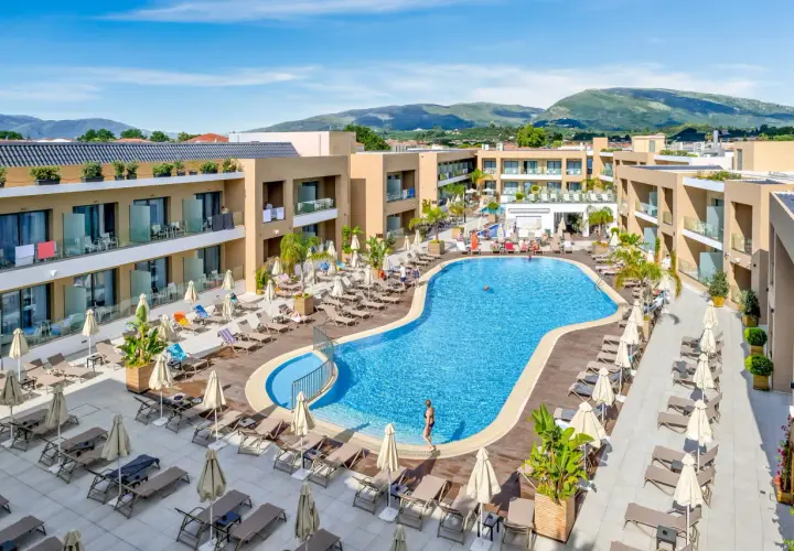 Luksusowy hotel White Olive Elite w Laganas, Grecja. Basen, leżaki i palmy tworzą idealne miejsce na relaks.