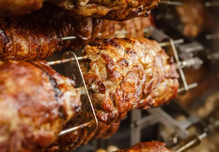 Cochon de lait grillé sur une rôtissoire. Quel vin avec cochon de lait grillé ? Un rouge fruité et léger serait parfait.