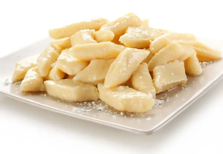 Pyszne leniwe pierogi na talerzu. Idealne co na obiad dla dzieci, posypane cukrem pudrem.