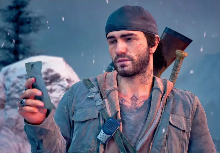 Deacon z Days Gone 2 PS4, w czapce i z siekierą za plecami, trzyma w dłoni znaleziony przedmiot.