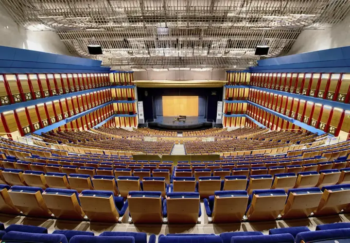 El **palacio de festivales** luce vacío, con sus butacas azules y doradas listas para recibir al público. Un piano espera en el escenario.