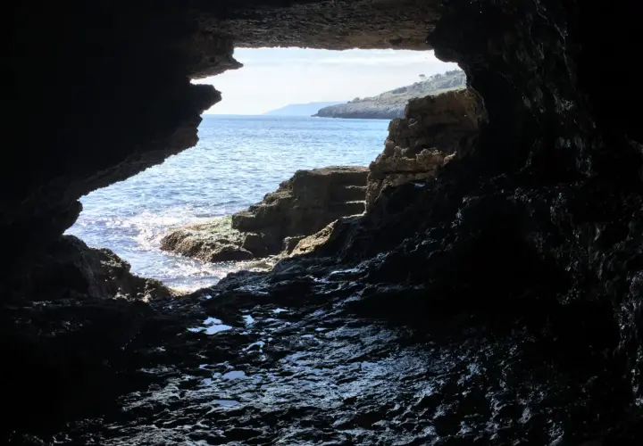 Vista dall'interno di una grotta sul mare cristallino e la costa rocciosa. La spiaggia della grotta verde è un luogo magico.