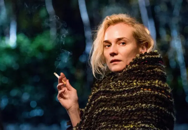 Diane Kruger w filmach, z papierosem w dłoni, otulona w gruby szal.