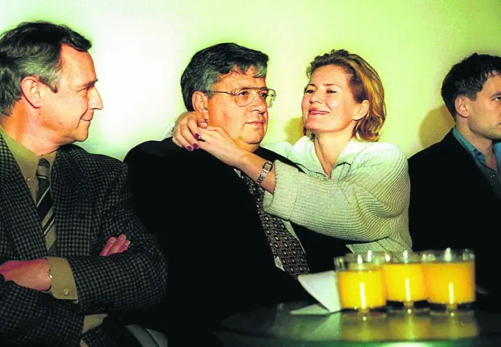 Lew Rywin, otoczony przez ludzi, z kobietą obejmującą go czule.