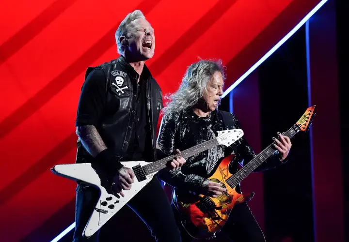 James Hetfield i Kirk Hammett z zespołu Metallica grają na gitarach podczas koncertu.