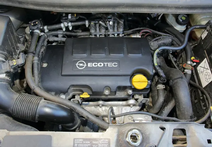 Silnik Ecotec w Oplu Meriva 1.4 benzyna. Widoczne przewody, wtryskiwacze i osłona silnika.