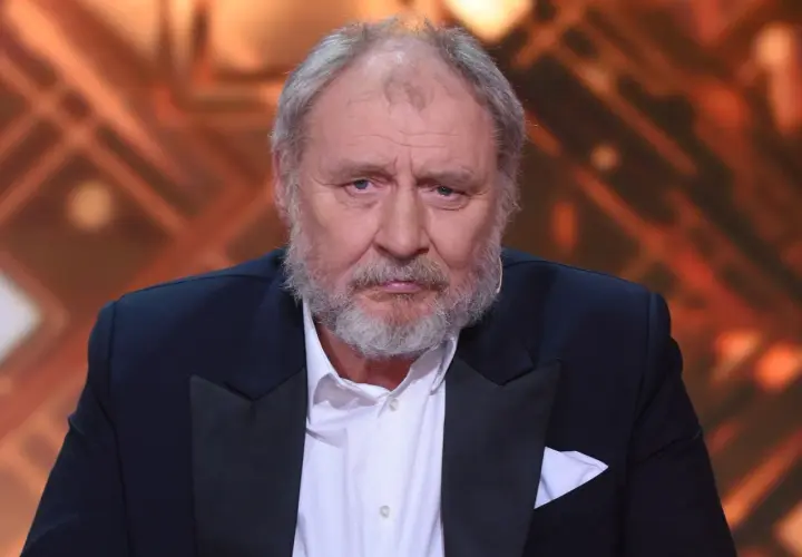Andrzej Grabowski, znany z roli Ferdynanda Kiepskiego, w eleganckim garniturze. Jego wiek dodaje mu powagi.