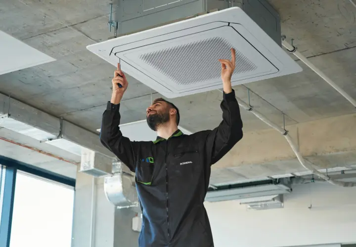 Técnico instalando equipos de climatización en el techo.