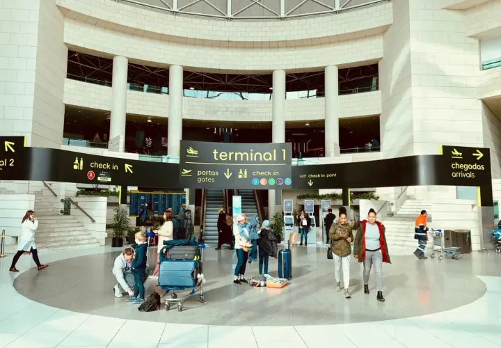 Menschen mit Gepäck im Terminal 1 des Lissabon Flughafens, bereit für die Weiterreise in die Stadt.