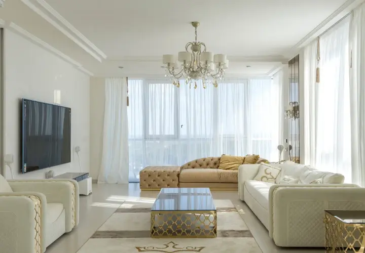 Elegancki salon z białymi sofami i złotymi akcentami. Czy można łączyć srebro ze złotem w domu? Tak, tworząc luksusową przestrzeń.