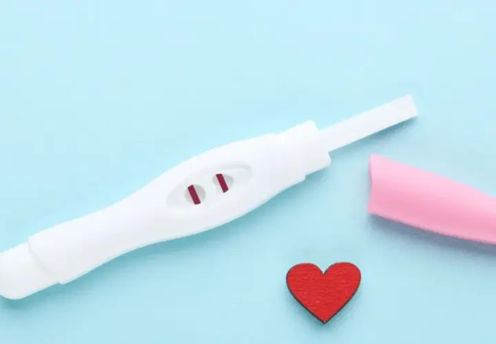 Test ciążowy z dwoma czerwonymi kreskami, różowa nakładka i serduszko. Kiedy zrobić test ciążowy?