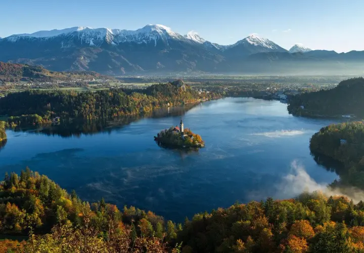 Jezioro Bled ze swoją malowniczą wyspą i kościołem to jedna z najpiękniejszych słowenia atrakcje. W tle majestatyczne Alpy.