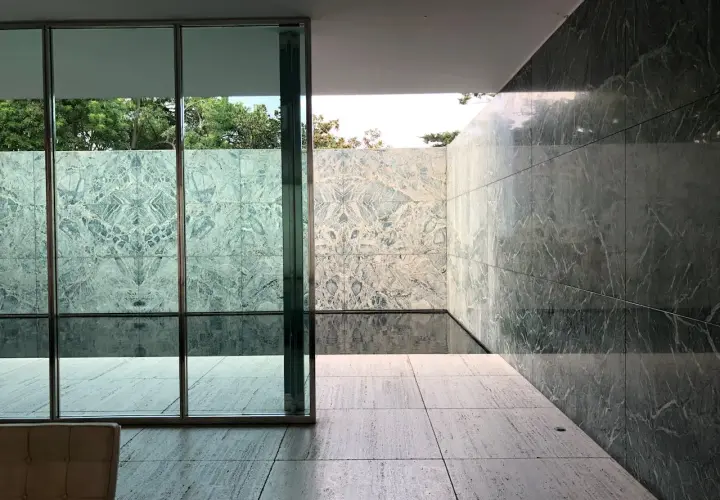 Pavimenti in travertino pro e contro: un'elegante terrazza con pareti in marmo verde e un piccolo specchio d'acqua.