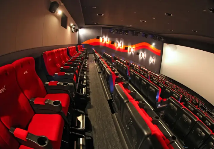 Puste czerwone fotele kinowe z logo 4DX czekają na widzów.