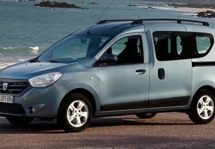 Auto blu con porte scorrevoli parcheggiata sulla costa. Ideale per avventure familiari al mare.