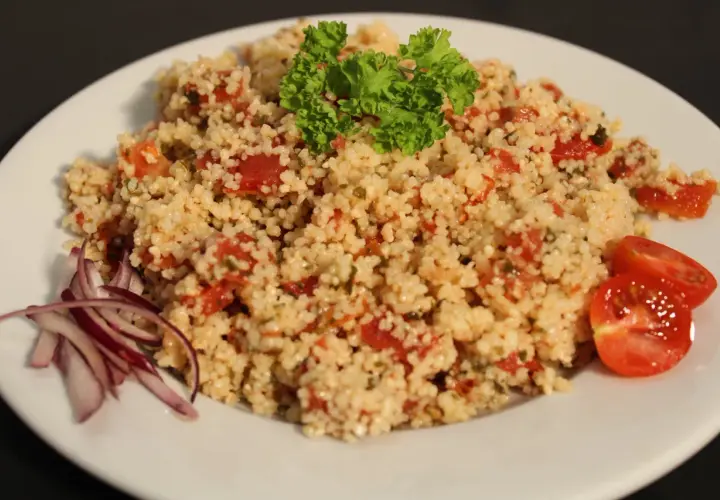 Taboulé traiteur frais, garni de persil et tomates. Le prix est très attractif pour cette spécialité méditerranéenne.