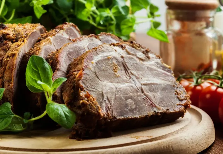 Rozpływająca się karkówka z piekarnika, soczysta i aromatyczna, podana z ziołami i pomidorkami.