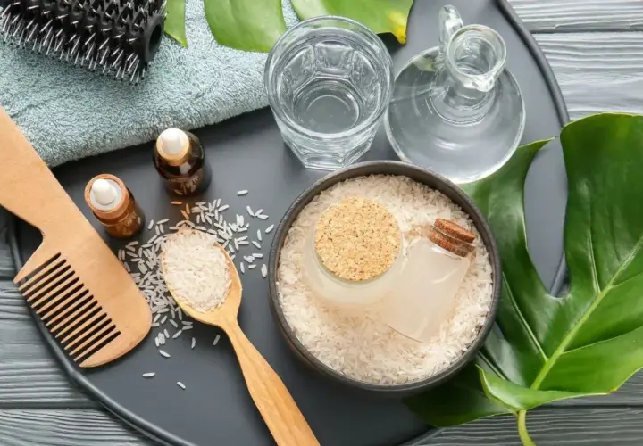 Ingredientes para el agua de arroz para el pelo: arroz, aceites, peine de madera, cepillo y toalla.