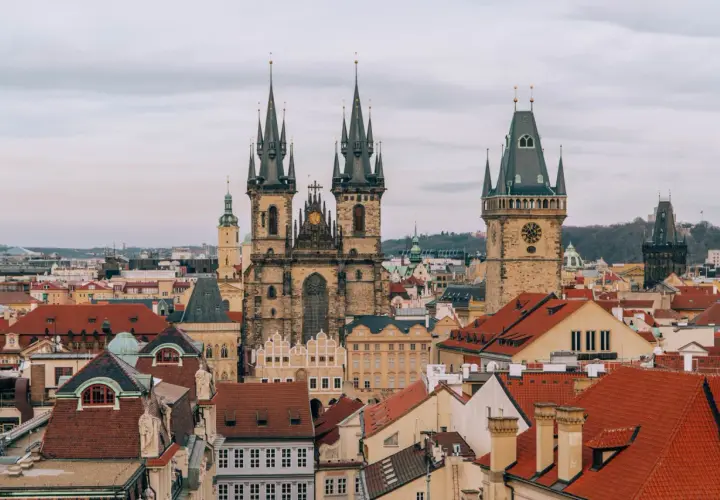 Widok na praską Starówkę z wieżami kościoła Marii Panny przed Tynem i Ratuszem Staromiejskim. W oddali widać nowoczesne budynki, a gdzieś tam pewnie jedzie pociąg w Czechach.