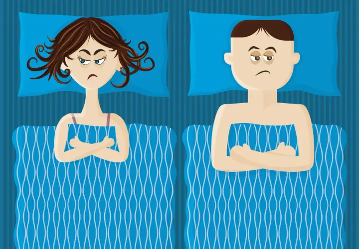 Coppia a letto, lei con sguardo infastidito, lui con espressione stanca. Sembra che lei non mi piace fare sesso e lui vorrebbe solo dormire.