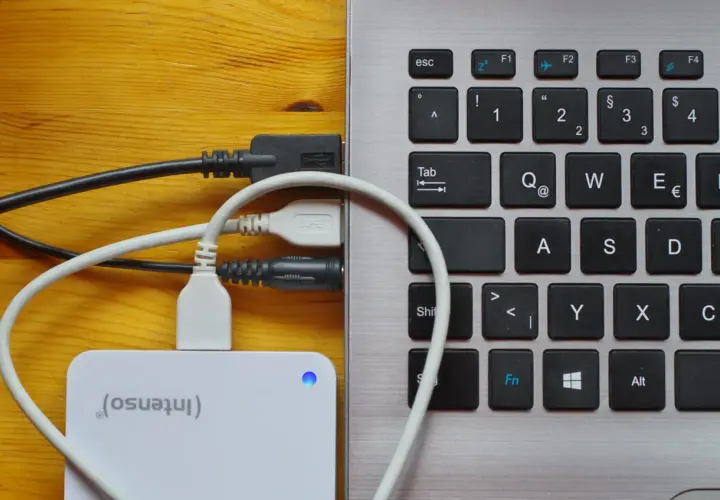 Externe Festplatte wird als USB-Laufwerk erkannt. Kabel verbinden die Festplatte mit dem Laptop.
