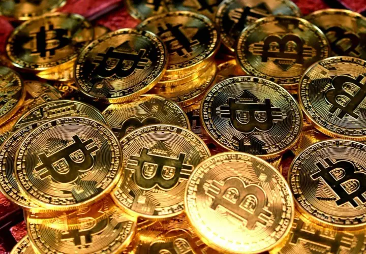 Złote monety z symbolem Bitcoina, symbolizujące jego wartość.