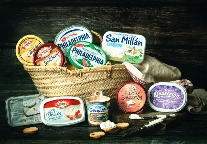 Variedad de quesos crema en cestas y recipientes, incluyendo marcas como Philadelphia y Président. Ideal para untar y disfrutar.