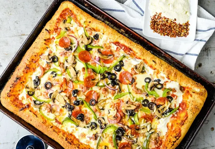 Pyszny przepis na pizzę z serem, pepperoni, pieczarkami, papryką i oliwkami. Idealna na rodzinny obiad.