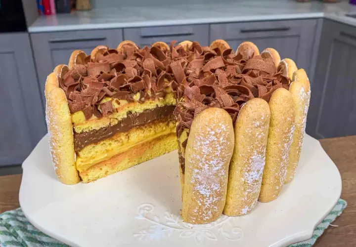 Una deliziosa zuppa inglese ricetta facile, con strati di pan di Spagna, crema pasticcera e cioccolato, decorata con savoiardi e riccioli di cioccolato.